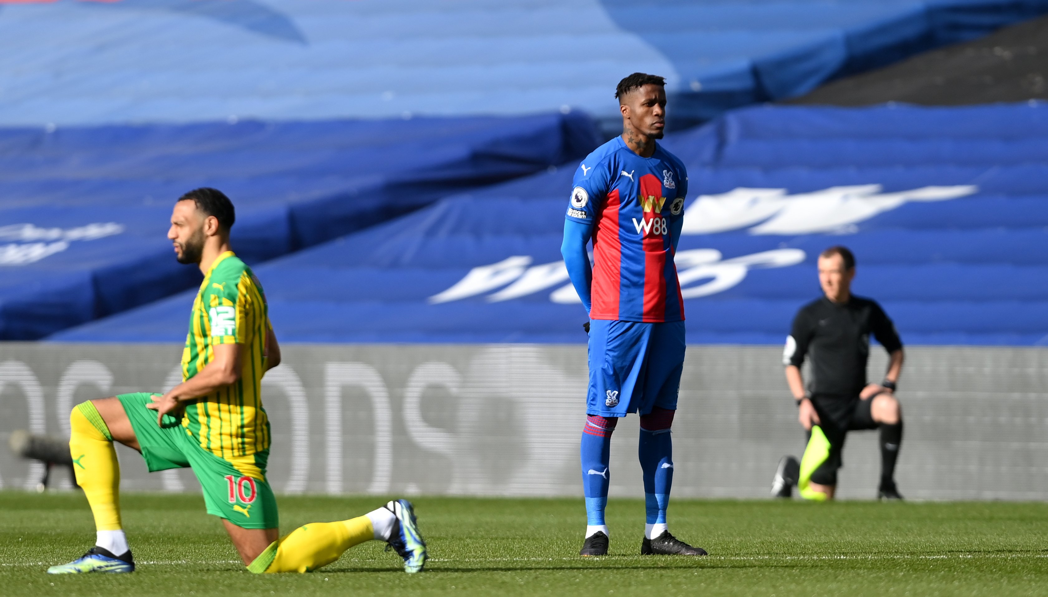 Crystal Palace's Wilfried Zaha stands while out players take a knee prior to the Premier League match at Selhurst Park, London.