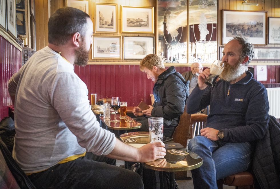 Customers enjoy a drink in a British pub