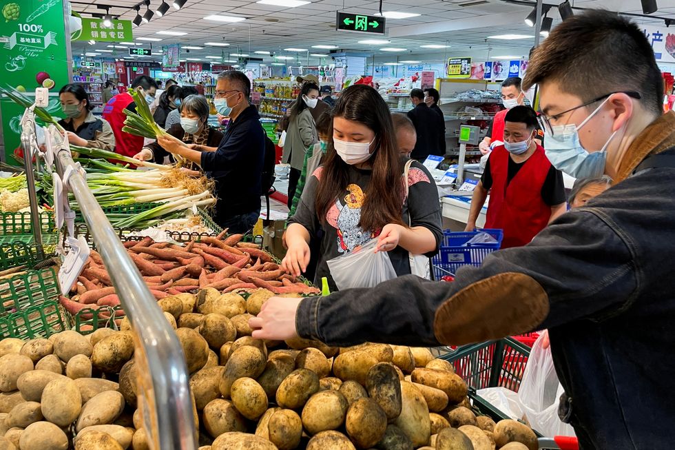 Customers wearing face masks shop at the vegetables section of a supermarket following the coronavirus disease (COVID-19) outbreak in Beijing, China April 25, 2022. REUTERS/Carlos Garcia Rawlins