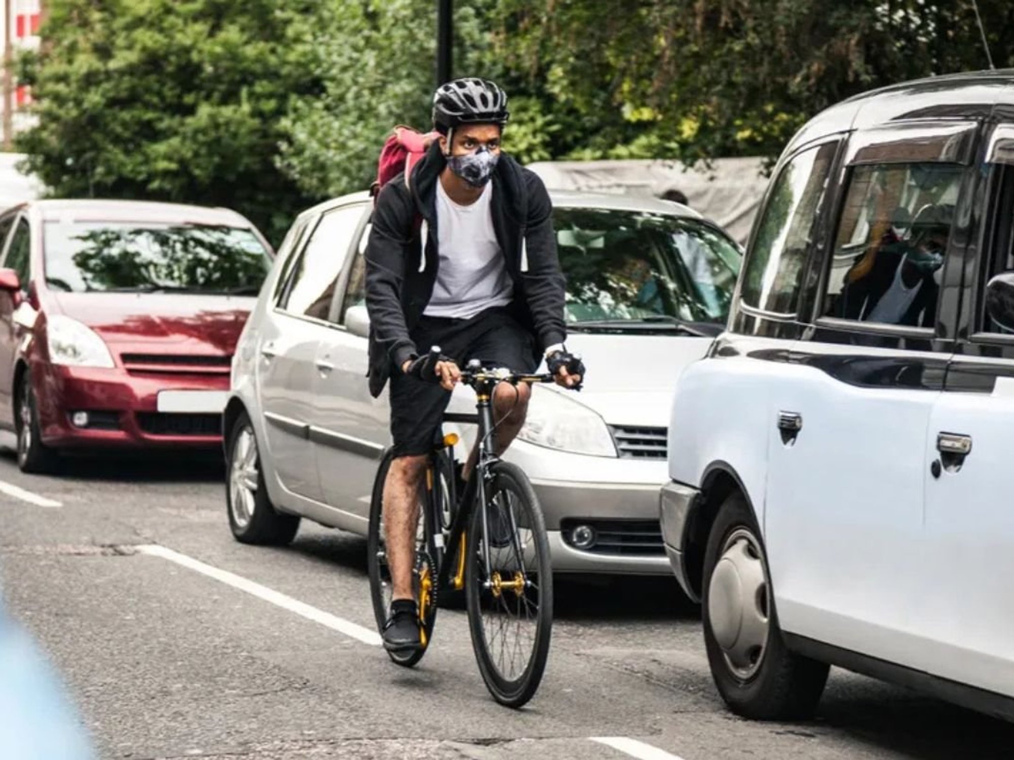 Cycling riding past cars