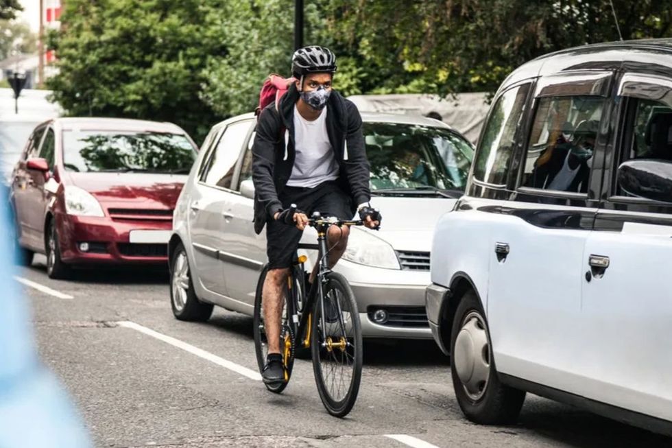 Cycling riding past cars