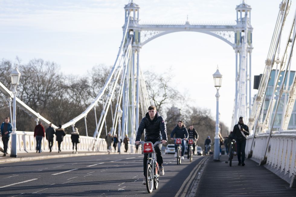 Cyclists ride their bike across Albert Bridge in Battersea, London. Picture date: Sunday January 30, 2022.