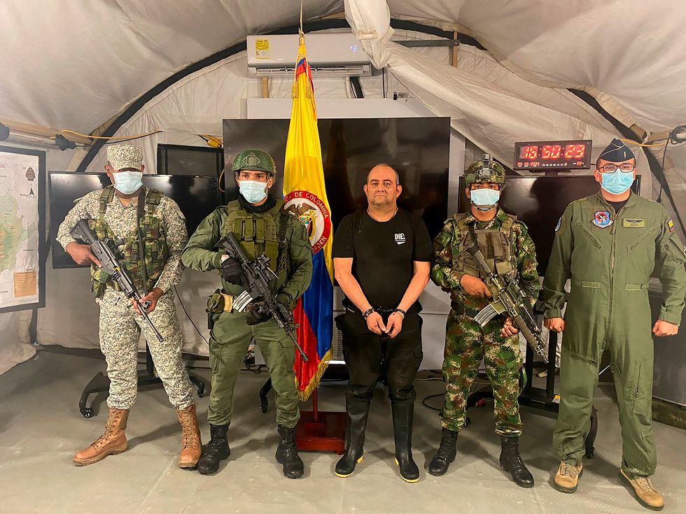 Dairo Antonio Usuga David, alias "Otoniel", top leader of the Gulf clan, poses for a photo escorted by Colombian military soldiers after being captured, in Necocli, Colombia October 23, 2021.