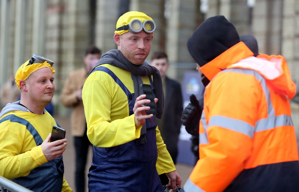 Darts fans in fancy dress show their covid pass ahead of day eleven of the William Hill World Darts Championship at Alexandra Palace, London. Picture date: Tuesday December 28, 2021.