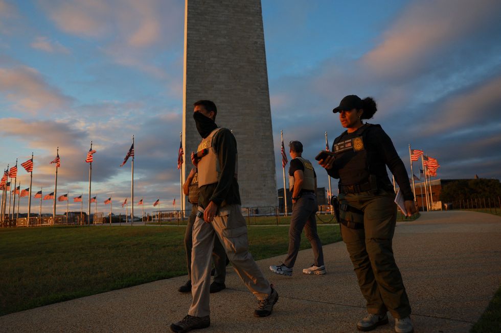 DEA agents walk past the Washington Monument after being deployed to the US capital
