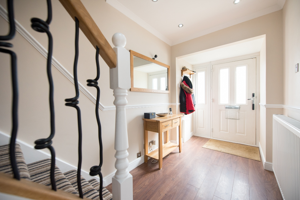 Decluttered hallway with door hooks and a hall table