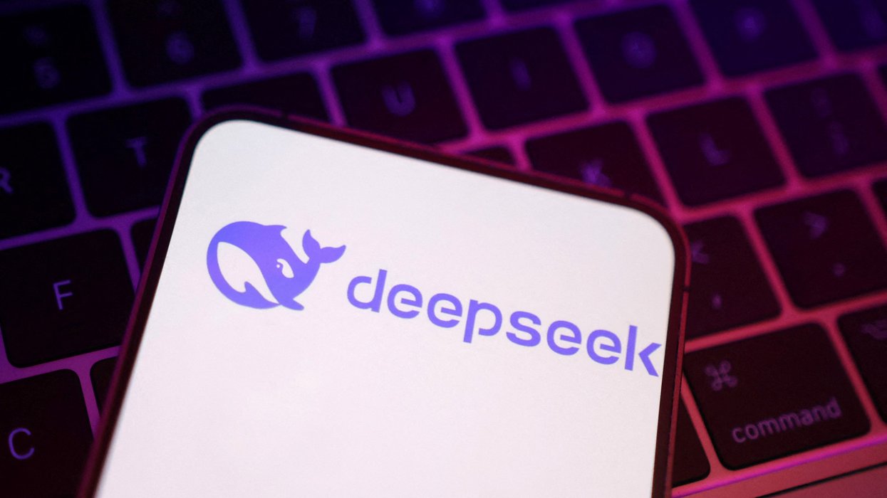 DeepSeek AI logo on an iPhone screen pictured lying on a laptop keyboard
