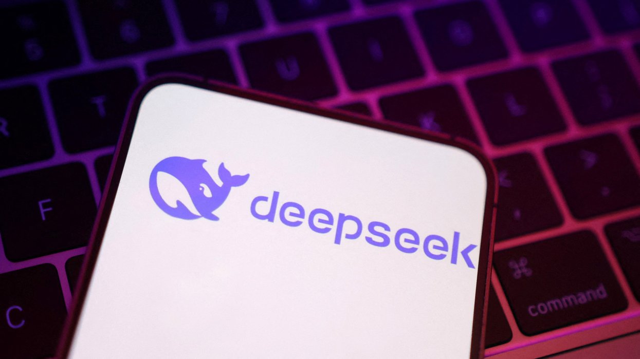 DeepSeek AI logo on an iPhone screen pictured lying on a laptop keyboard
