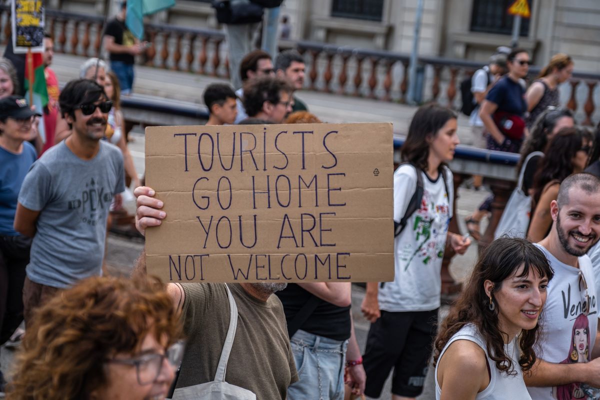 Demonstrator holding 'Tourists go home' sign during Mallorca anti-tourism protests