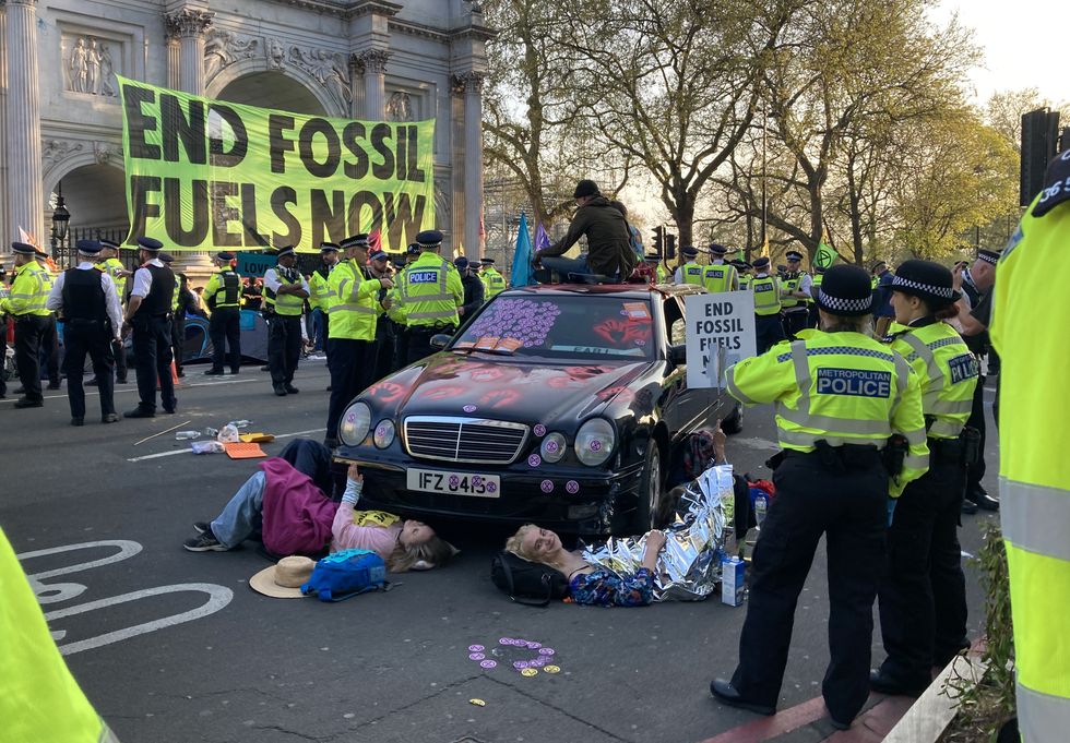 Demonstrators glued to a car during an Extinction Rebellion protest at Marble Arch in central London. Picture date: Saturday April 16, 2022.
