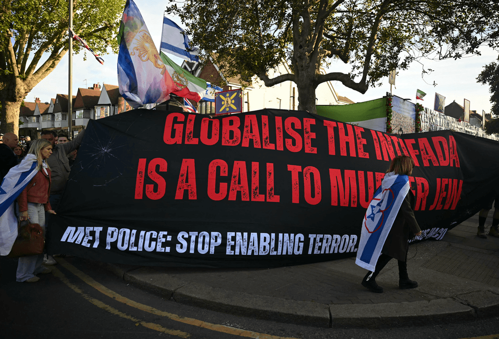 Demonstrators hold a banner reading 'Globalise the Intifada is a Call to Murder Jews' as they protest in the Golders Green neighbourhood of north London, on April 29, 2026, following the stabbing of two people earlier today.