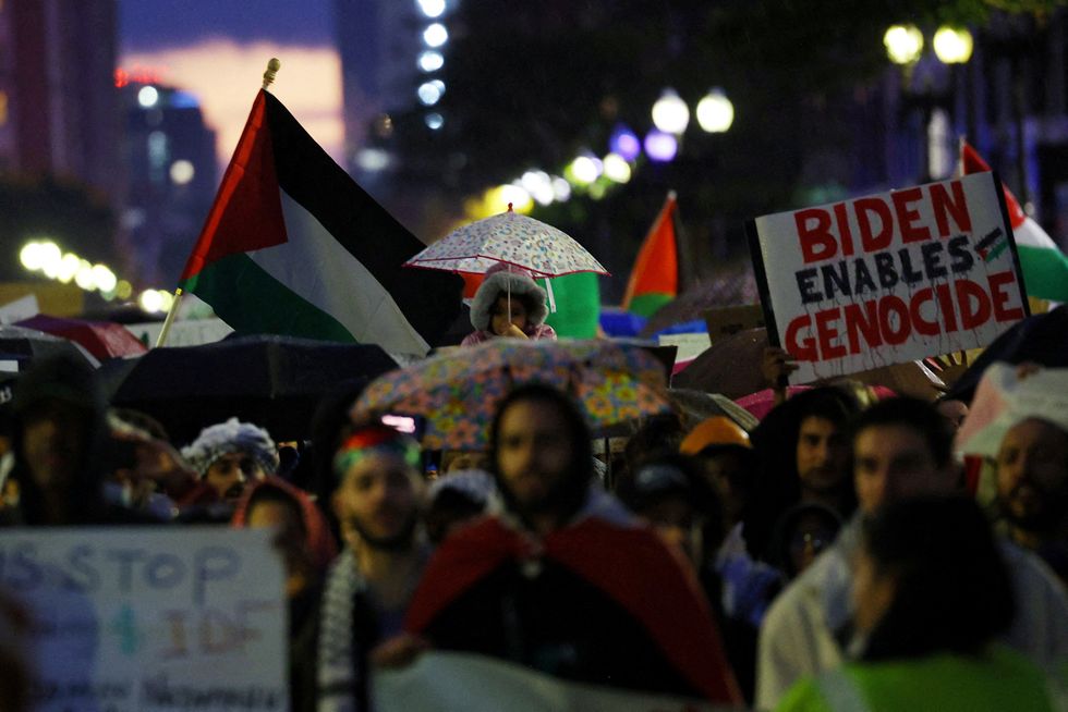 Demonstrators, including one carrying a placard that reads "Biden Enables Genocide", take part in the "We Won\u2019t Back Down: All Out for Palestine" protest in support of Palestinians, as the conflict between Israel and Hamas continues, in Boston, Massachusetts