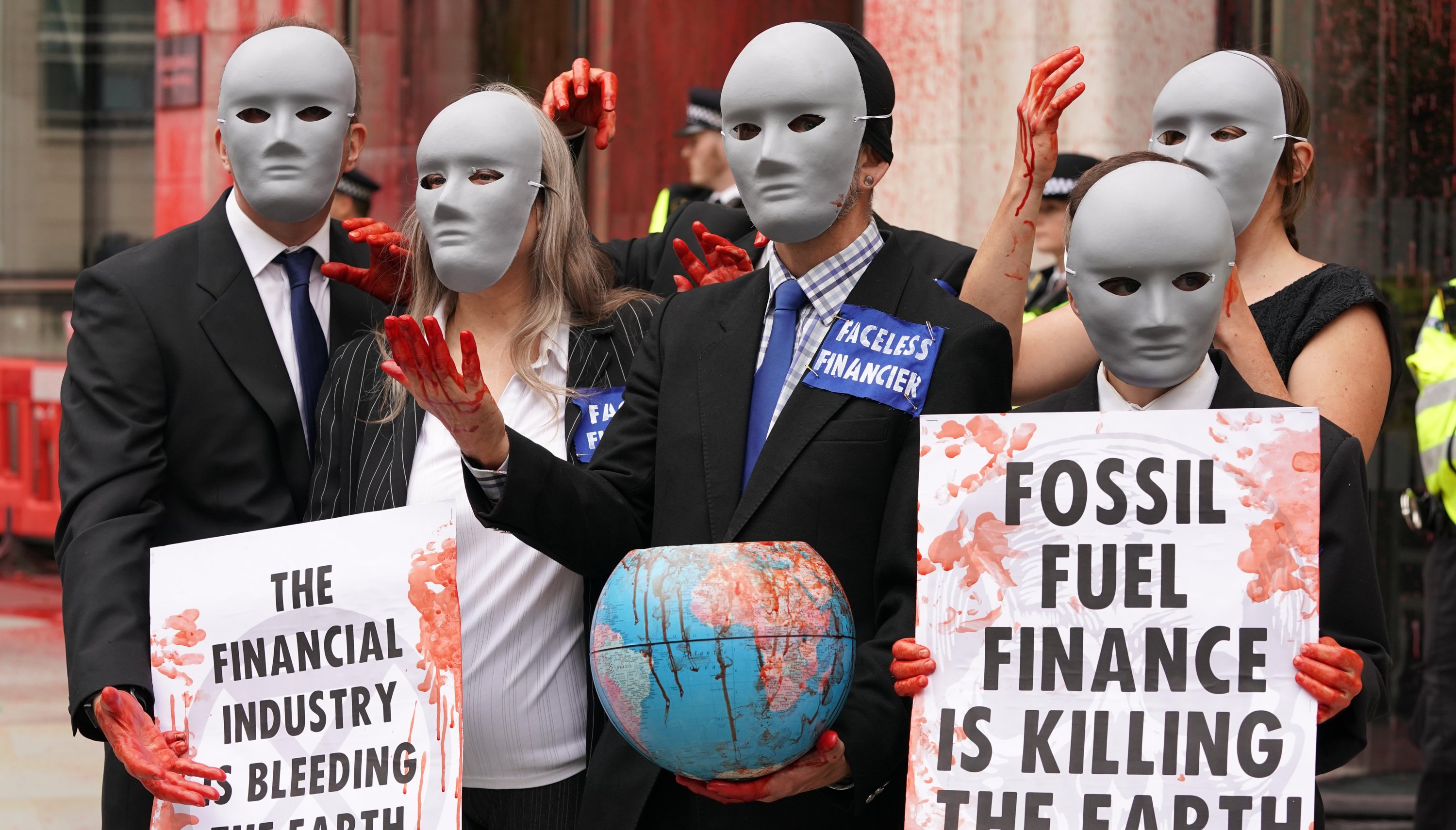 Demonstrators stand in front of one of the buildings of the Guildhall, which has been daubed in paint, as an Extinction Rebellion protest makes its way through the City of London.