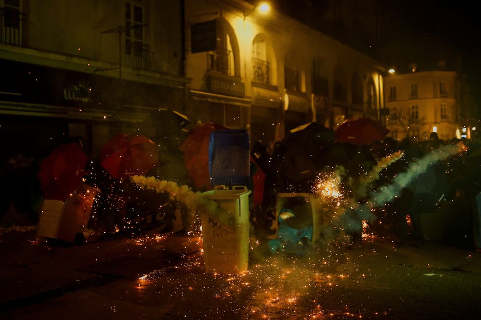 Demonstrators take cover behind umbrellas as they gather in Nantes to protest
