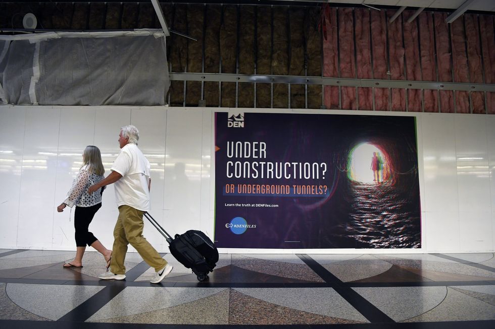 Denver International Airport hoardings which read 'under construction? or underground tunnels?'