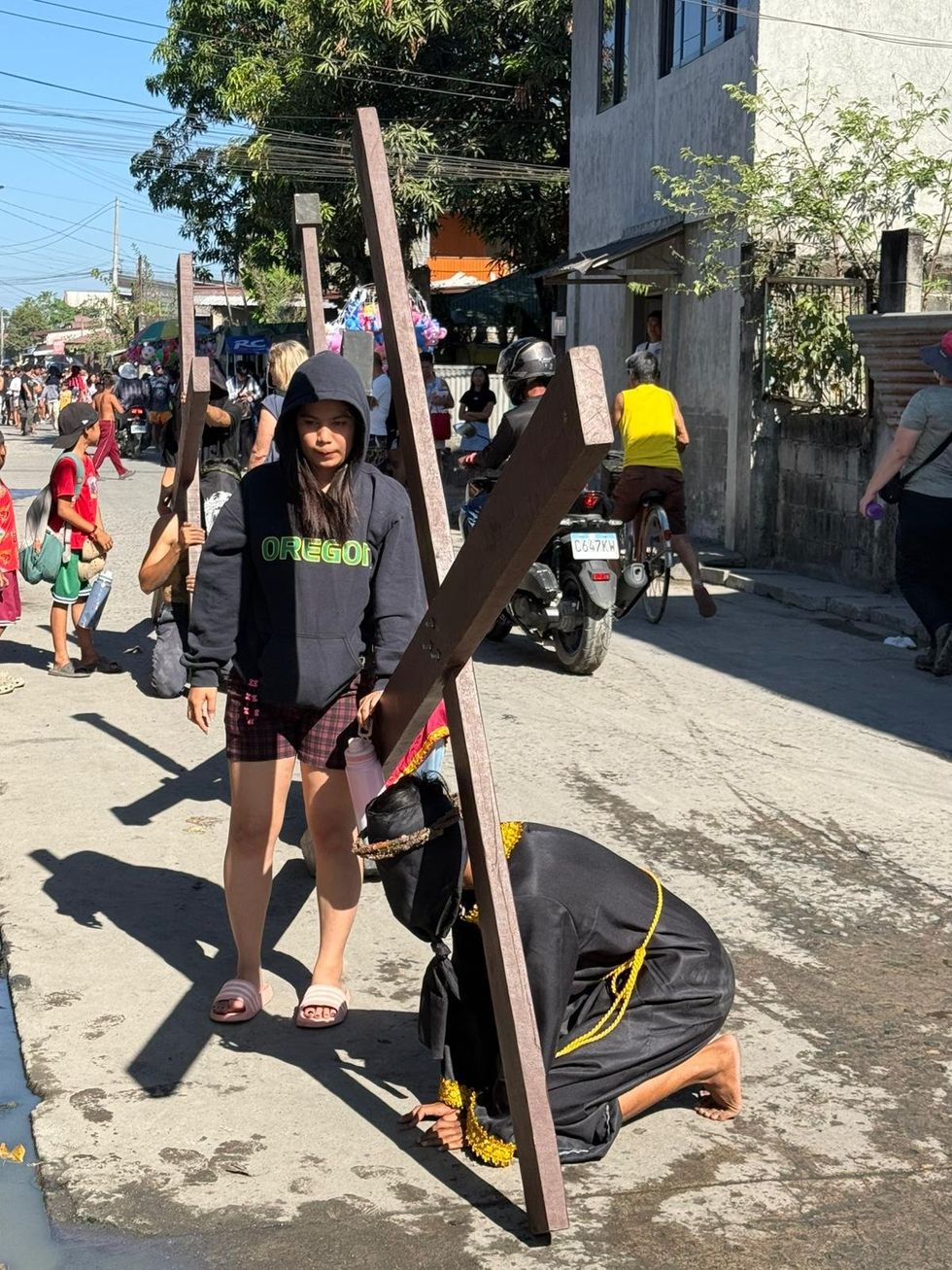 Devotos carregam uma cruz