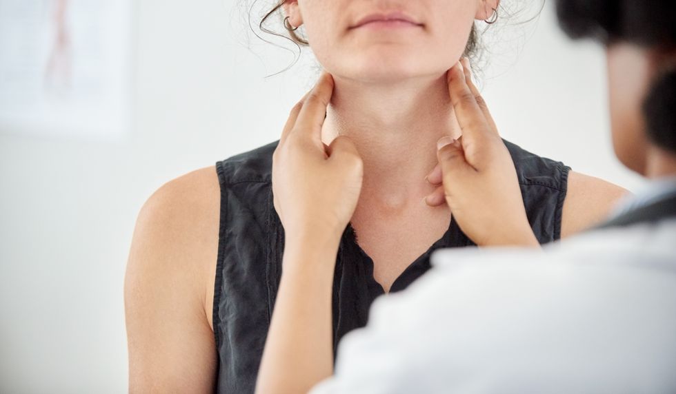 doctor checking patient thyroid