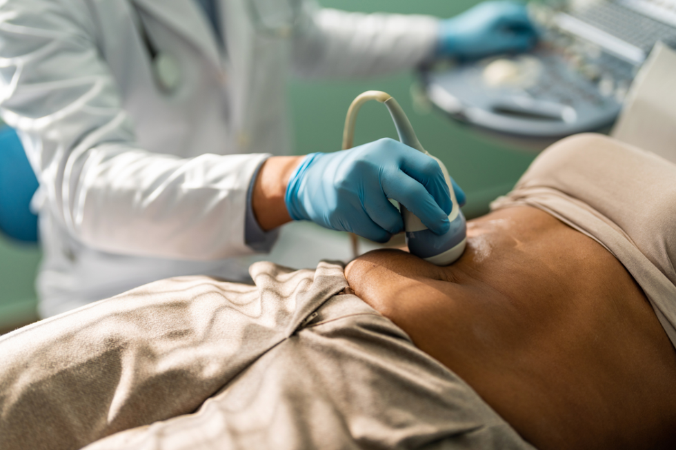Doctor conducting ultrasound of abdomen