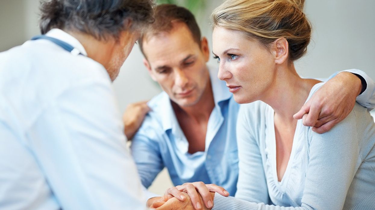Doctor consoling woman and her partner
