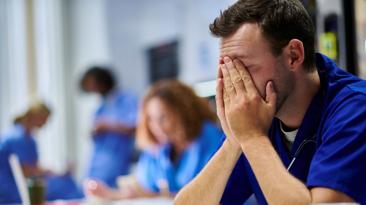 Doctor holding head in his hands