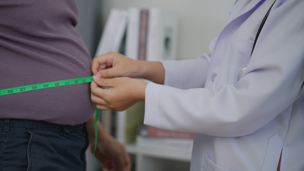 Doctor measuring a patient's stomach with tape