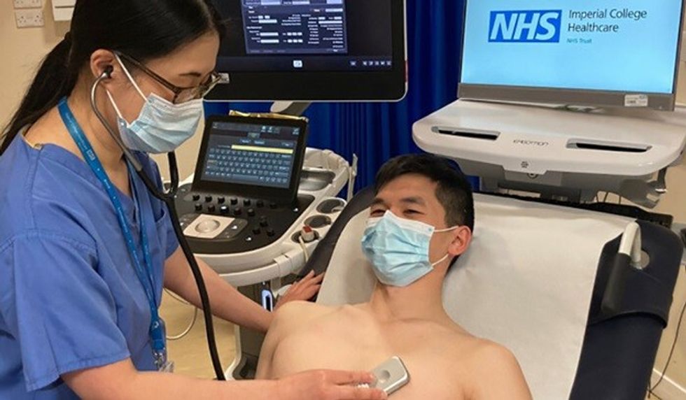 Doctor using AI stethoscope on patient