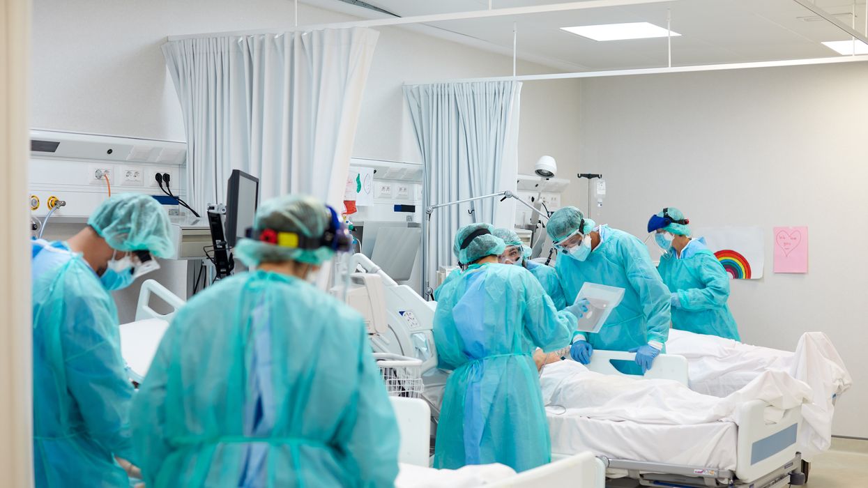 Doctors attending to patients in hospital beds