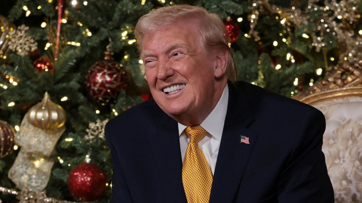 Donald Trump in front of a Christmas tree