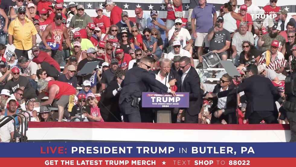 Donald Trump looks dishevelled after being raised up
