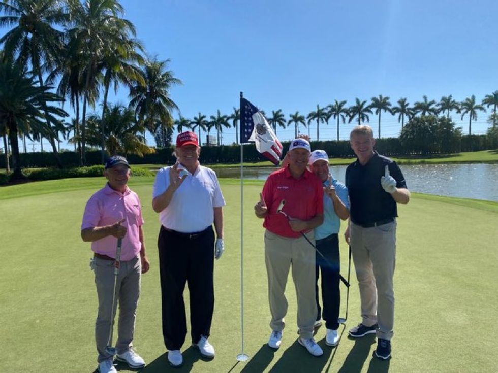 Donald Trump posing after hitting a hole-in-one