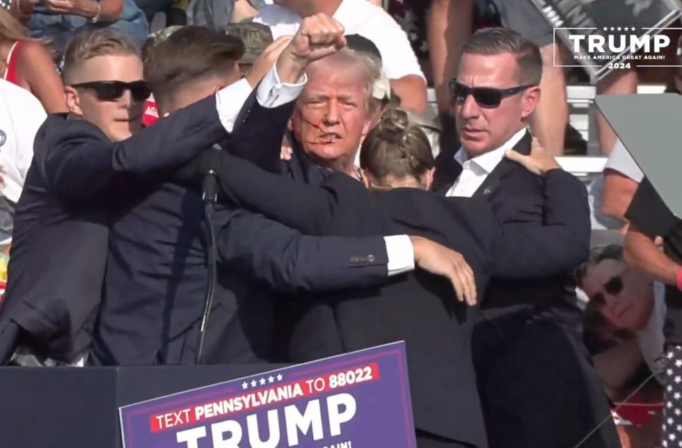 Donald Trump puts fist in the air after being shot at
