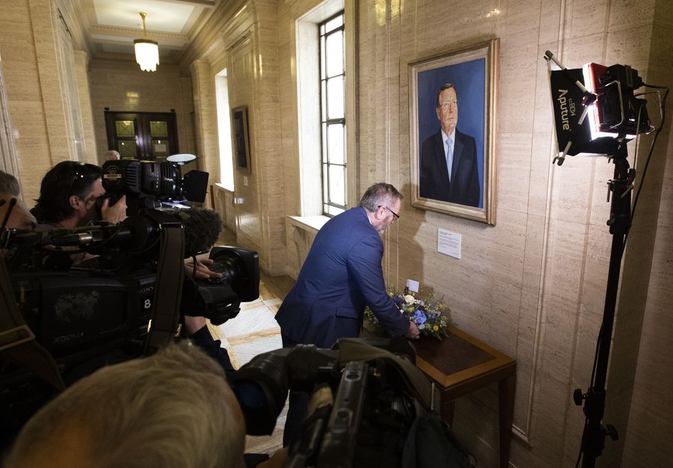Doug Beattie, leader of the Ulster Unionist Party (UUP) lays a wreath under the portrait of the party's former leader David Trimble, in the Great Hall of Parliament Buildings at Stormont, expressing condolences to the family of Mr Trimble who died on Monday. Books of condolence are opening across Northern Ireland in memory of former first minister David Trimble. Picture date: Tuesday July 26, 2022.