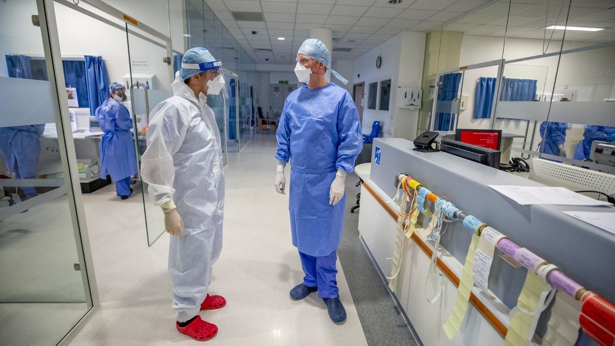 Dr Ascanio Trident (left), clinical director of intensive care at Whiston Hospital in Merseyside, wearing full personal protective equipment (PPE)