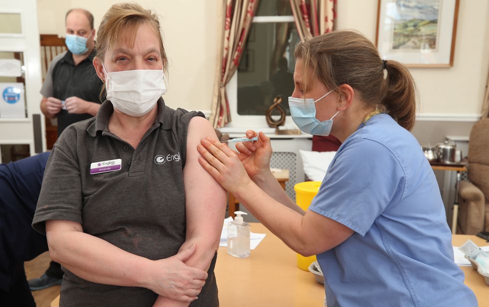 Dr Jess Harvey administers the second dose of Oxford/AstraZeneca coronavirus vaccine to care home assistant Amanda Lucas at the Lady Forester Community nursing home in Much Wenlock, Shropshire. Picture date: Thursday March 25, 2021.