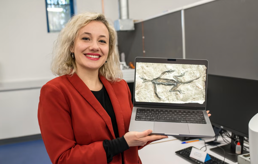 Dr Valentina Rossi poses with an image of Tridentinosaurus antiquus