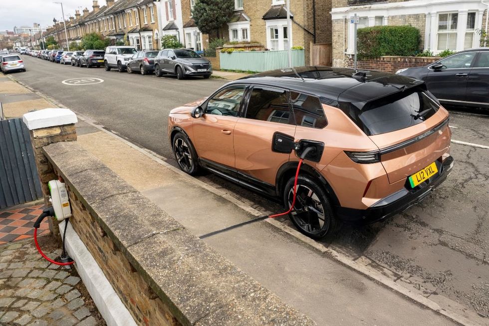 Driver charging Vauxhall electric car with a Kerbo Charge charger