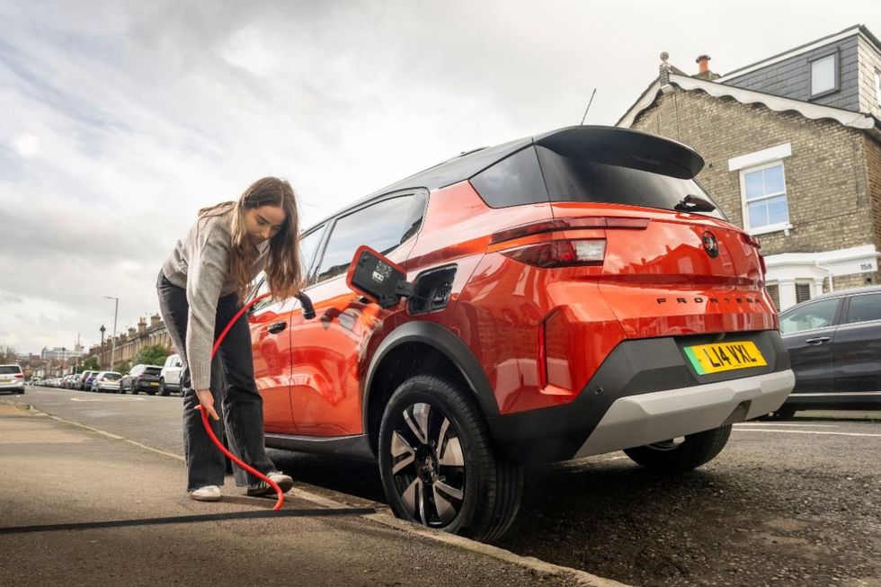 Driver charging Vauxhall electric car with a Kerbo Charge charger