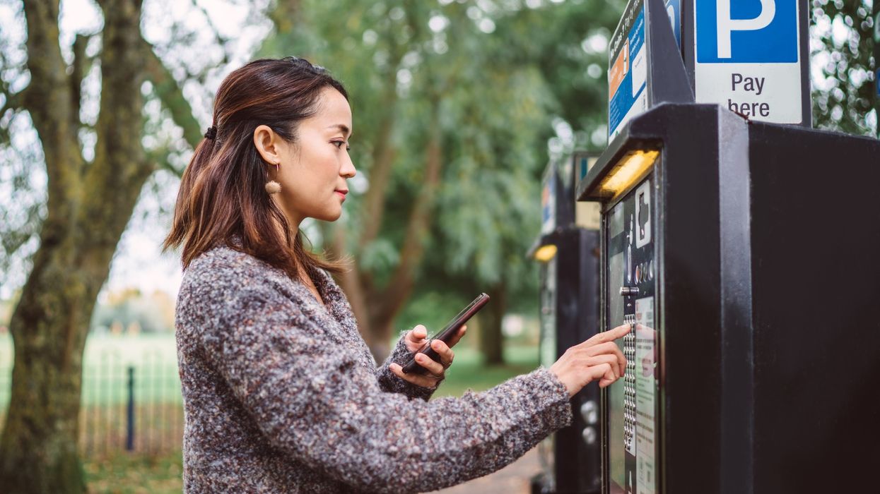 Driver paying for parking at metre