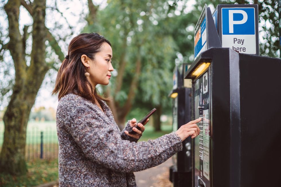 Driver paying for parking at metre