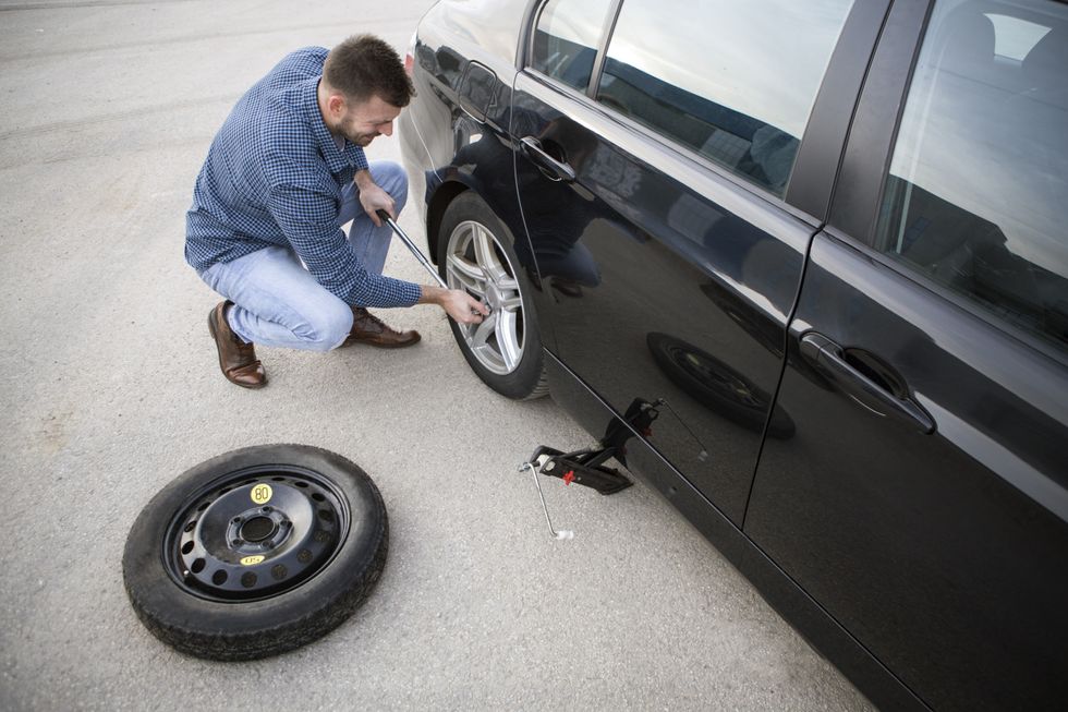 Driver replacing car tyres