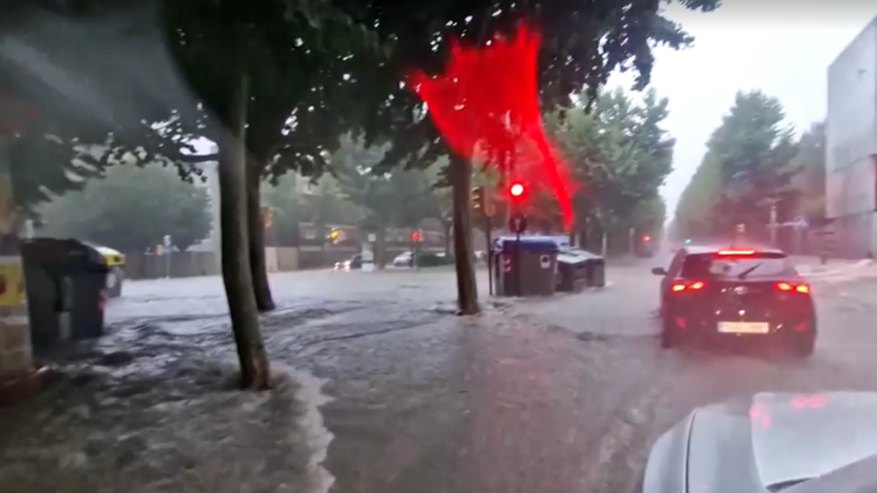Drivers are seen forcing their cars out of the floodwater