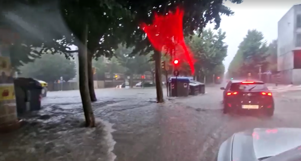 Drivers are seen forcing their cars out of the floodwater