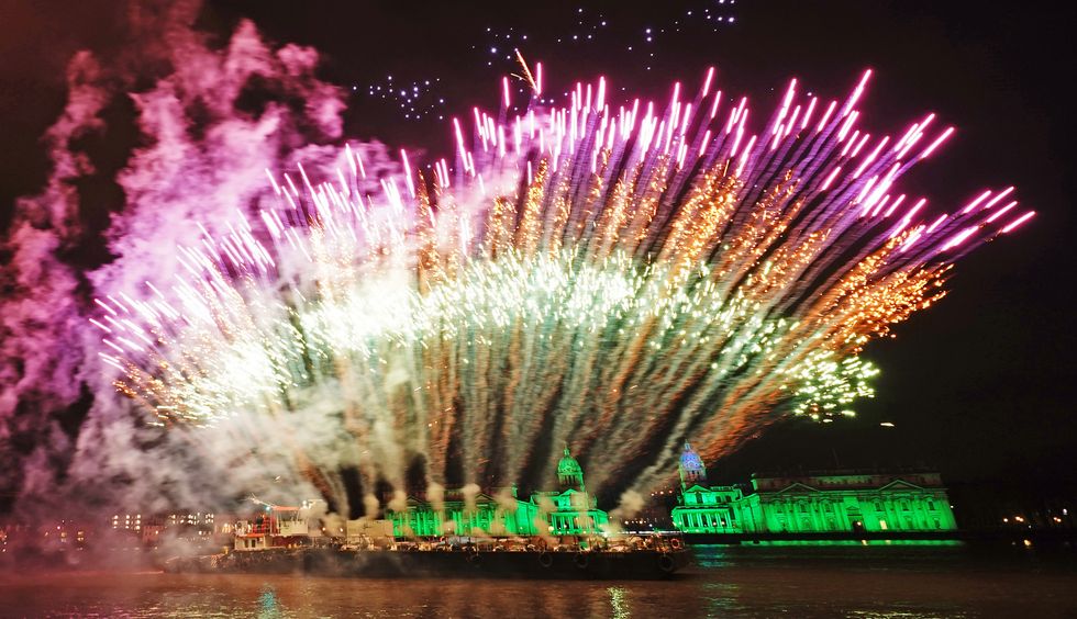 Drones and fireworks illuminate the night sky over the Old Royal Naval College in London after the capital's normal New Year's Eve fireworks display was cancelled due to the coronavirus pandemic. Picture date: Saturday January 1, 2022.