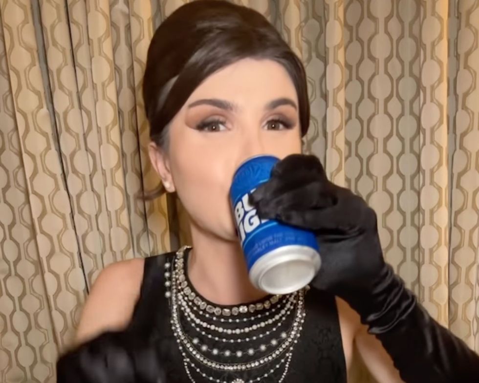 Dylan Mulvaney drinking a can of Bud Light