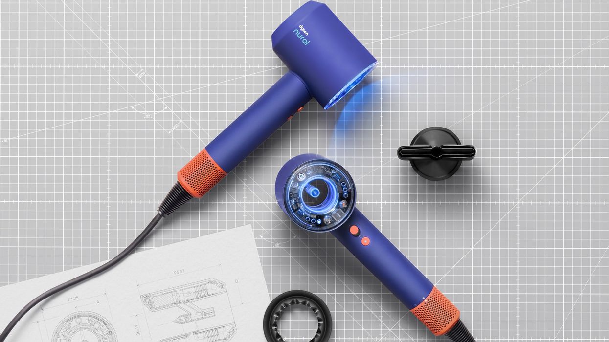 dyson supersonic nural pictured in the Vinca Blue and Topaz colour option on a design table with schematics