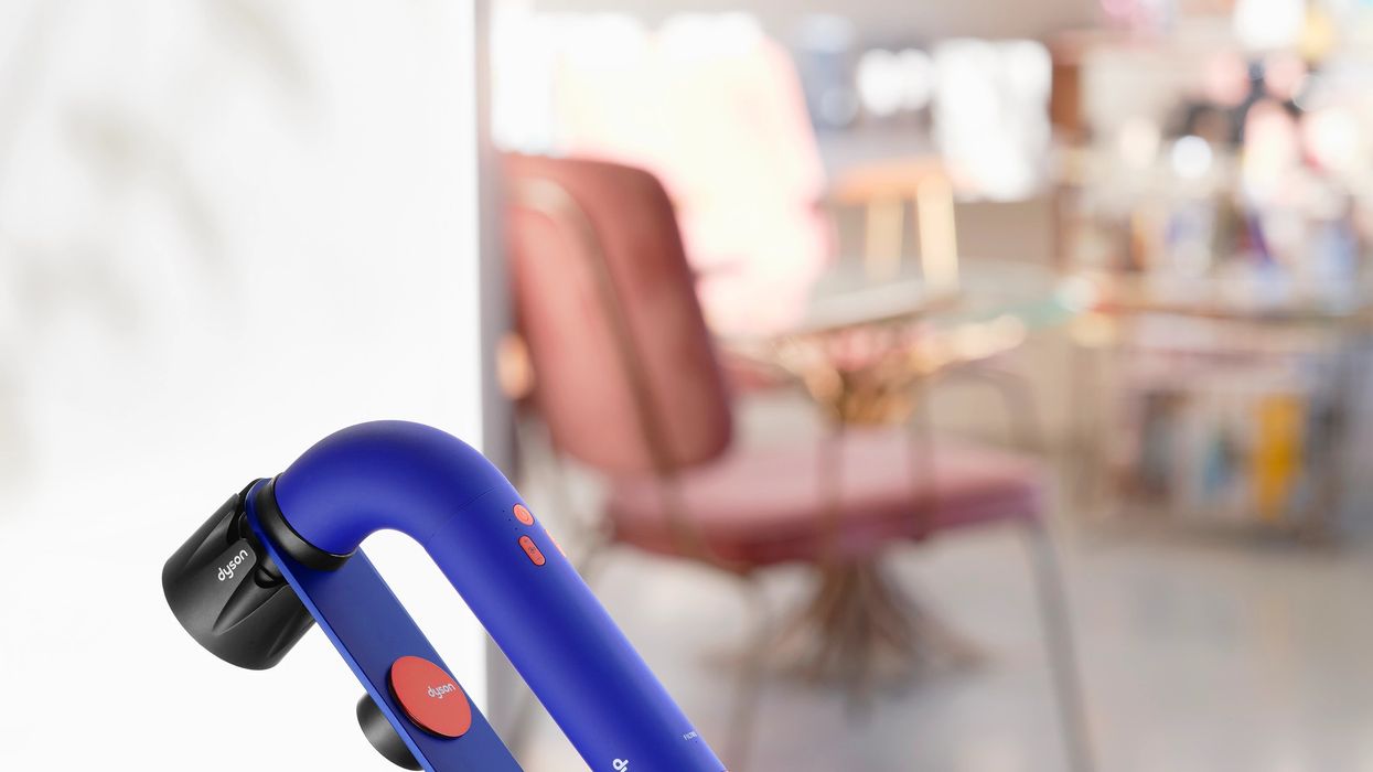 dyson supersonic r hair dryer pictured on a work surface charging