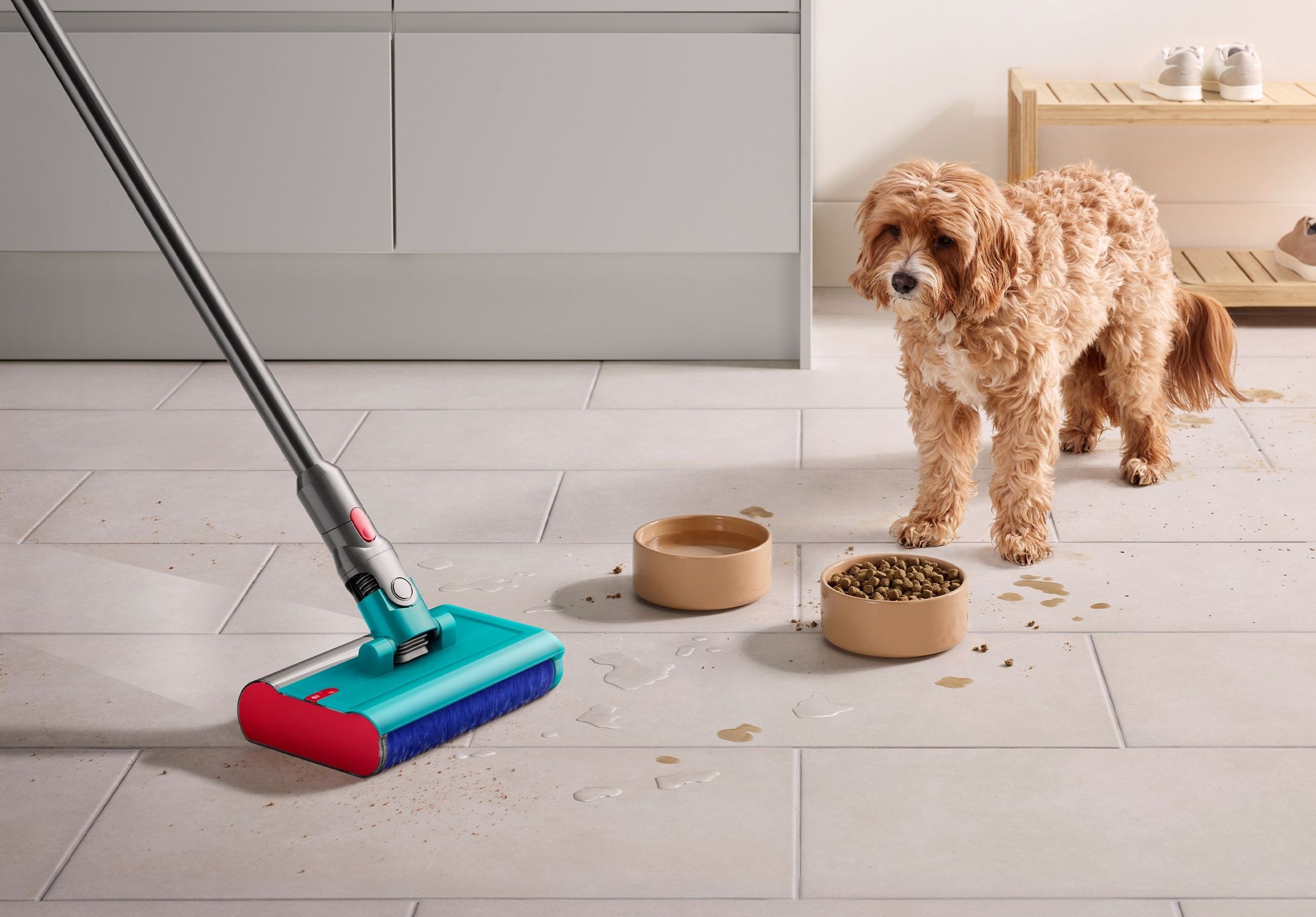 dyson v15 detect submarine shown mopping a spill on the floor while a pet dog looks on