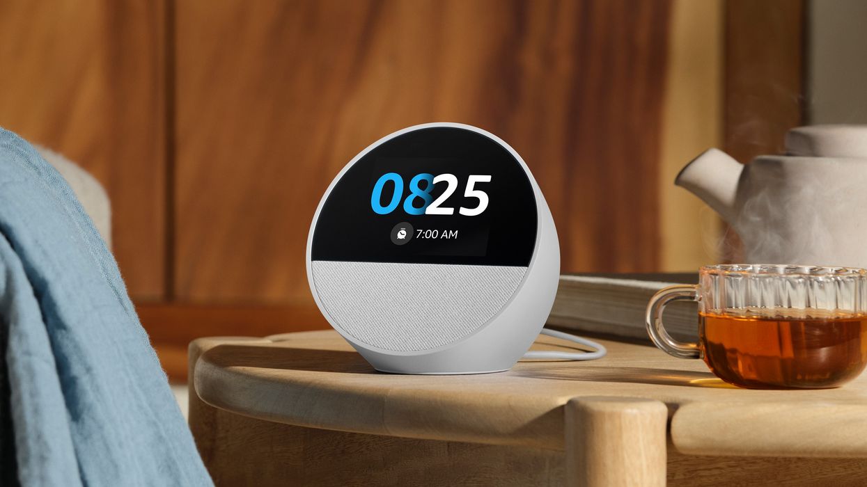 echo spot bedside clock pictured on a wooden table in Glacier White with a cup of tea beside it