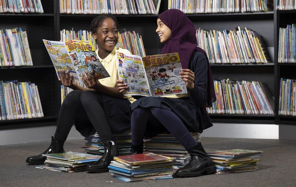 EDITORIAL USE ONLY (Left to right) Ahsoka Henry, age 11, and Maryan Abbas age 10, take part in the Beano's 'Libraries Aloud' reading initiative in partnership with the National Literary Trust. Issue date: Monday February 28, 2022.