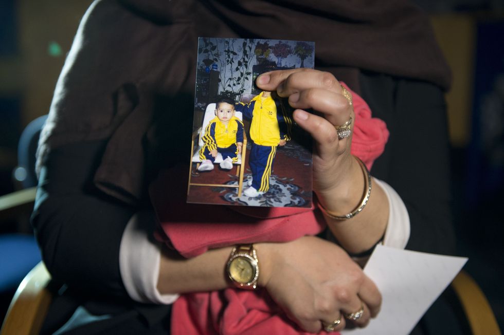 EDITORS NOTE: FACE IN PHOTO BEING HELD DELIBERATELY COVERED BY SISTER Renu, eldest sister of Shamima Begum, 15, holds her sister's photo while being interviewed by the media at New Scotland Yard, central London, as the relatives of three missing schoolgirls believed to have fled to Syria to join Islamic State have pleaded for them to return home.